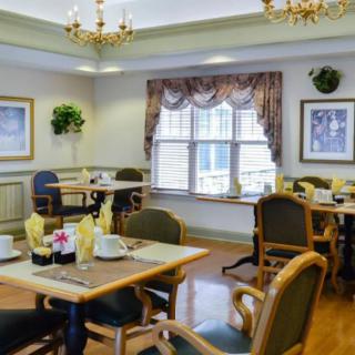 A well-decorated dining room featuring elegant chandeliers and neatly arranged tables and chairs.