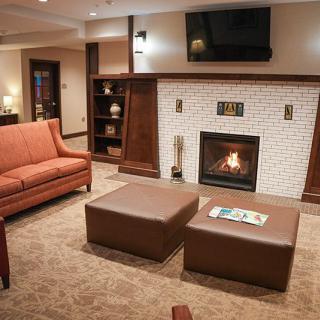 A cozy living room with a fireplace, sofa, and television, creating a warm and inviting atmosphere.
