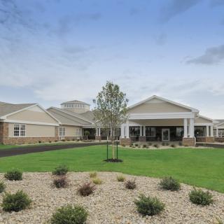 A large building with a landscaped lawn under a blue sky.