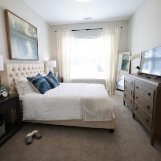 A serene and modern bedroom featuring a comfortable bed, elegant decor, and abundant natural light.