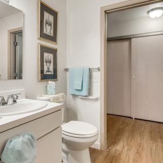 A clean and modern bathroom with a sink, toilet, and decorative artwork on the walls.