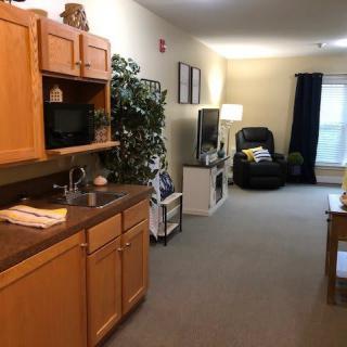 A cozy apartment interior featuring a kitchenette, comfortable seating area, and a mix of decor elements.