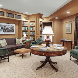 A cozy living room with built-in bookshelves and a central round table, creating a perfect reading nook.