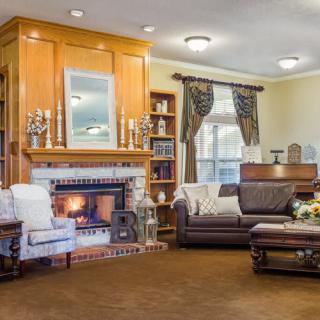 A cozy living room with a warm fireplace, comfortable seating, and elegant decor.