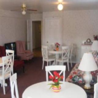 A cozy living and dining area with various pieces of furniture and decor.