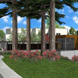 A well-landscaped park area with tall trees and a modern building in the background.