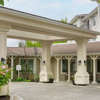 The entrance to a building with columns and a covered driveway.