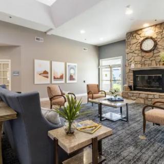 A cozy living room with comfortable seating, a stone fireplace, and stylish decor.