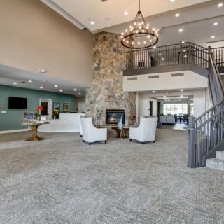 Spacious lobby with elegant chandelier, stone fireplace, and comfortable seating areas.