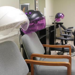A salon interior featuring hair dryers and comfortable chairs.