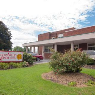 The exterior view of a healthcare facility with surrounding greenery and a visible entrance sign.