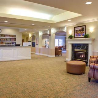A spacious lobby with a reception desk, fireplace, and seating area.
