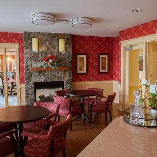 A cozy living room with a fireplace, red walls, and comfortable seating.