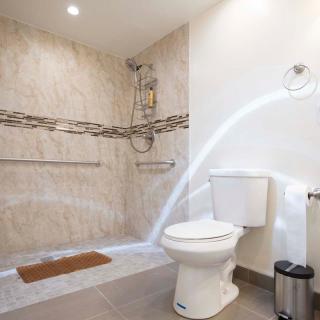 A modern bathroom with a shower area and toilet, featuring a water stream.