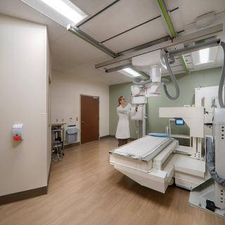A hospital room equipped with an X-ray machine, ready for patient examinations.