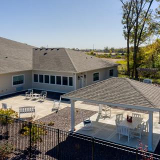 A spacious backyard features a patio area with outdoor seating and a gazebo, surrounded by well-maintained landscaping.