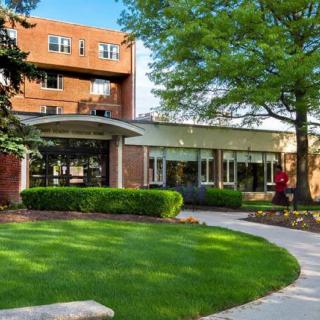 A building surrounded by lush greenery and a winding pathway.