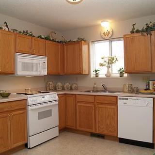 A cozy kitchen with wooden cabinets and white appliances.