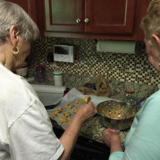 Two people collaborating in the kitchen, preparing a dish.