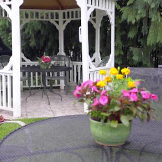 A serene garden setting featuring a gazebo surrounded by colorful flowers.