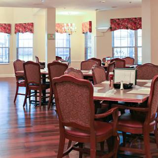 A cozy dining room with elegant furniture and wooden floors.
