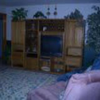 A cozy living room featuring a large entertainment center with a television.
