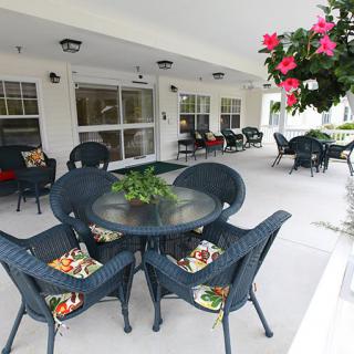 A cozy outdoor patio area with seating arrangements and floral decorations.