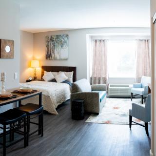 A modern studio apartment featuring a combined living and sleeping area with contemporary furniture.