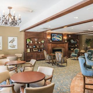 A cozy lounge area featuring comfortable seating, a fireplace, and elegant decor.