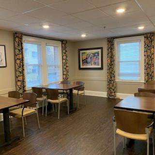 A cozy dining area with tables, chairs, and decorative artwork on the walls.
