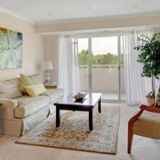 A cozy living room with a sofa, coffee table, and natural lighting from the large window.
