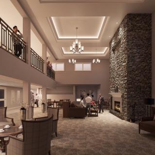 A spacious and modern living room with a stone fireplace and chandelier.