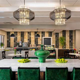 A stylish dining area featuring modern pendant lights, a green color scheme, and elegant decor.