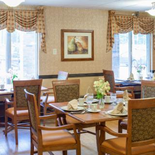 A cozy dining area featuring well-set tables and comfortable seating.