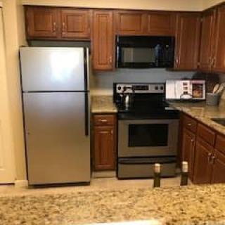 A modern kitchen with stainless steel appliances and wooden cabinets.
