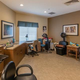 A cozy office space with a desk, chairs, and various decorations.