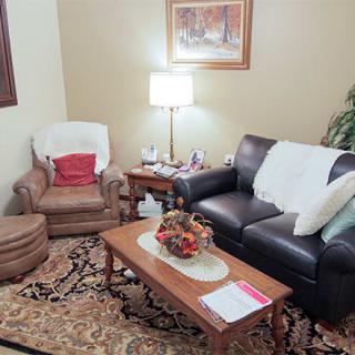 A cozy living room with a sofa, armchair, and coffee table.