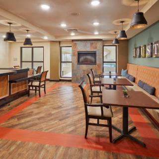 A modern dining area featuring stylish furniture and warm lighting.