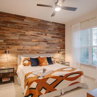 A cozy bedroom with a modern wood accent wall and stylish decor.