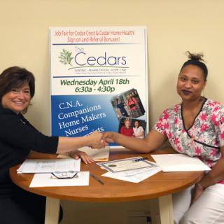 Representatives shaking hands to celebrate a new partnership at Cedars for health services.