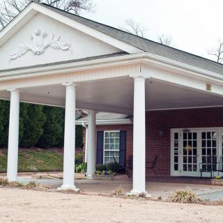 A building entrance with a covered walkway supported by columns.