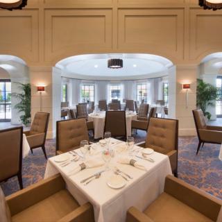 Elegant dining room with neatly arranged tables and chairs.