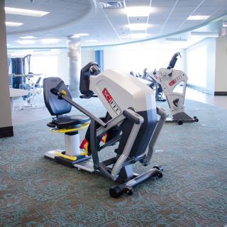 A modern gym with exercise equipment lined up in a spacious, well-lit room.