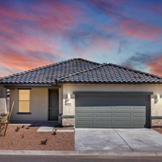 A modern single-story house with a two-car garage at sunset.