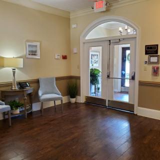 A cozy lobby area with wooden flooring, featuring seating and decorative elements.