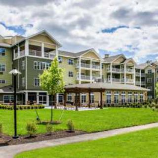 A modern apartment complex with a well-maintained green lawn and landscaping.