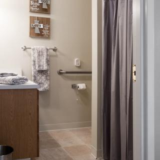 A well-organized bathroom with a sink, towels, and a shower curtain.