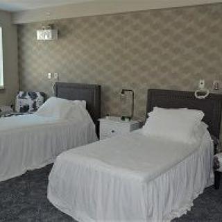 A neatly organized hotel room featuring two beds with white linens.
