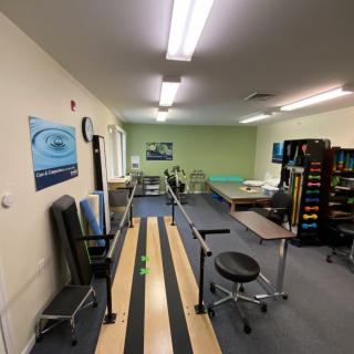 A physical therapy room equipped with various rehabilitation tools and treatment areas.