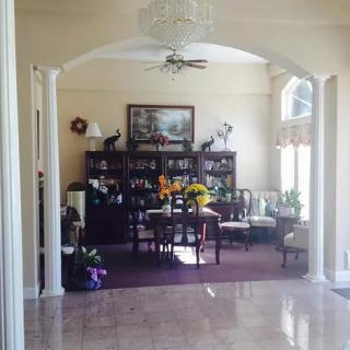 A beautifully decorated living room featuring an archway, chandelier, and bookshelf.